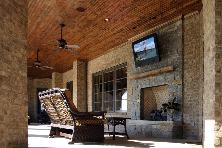 Outdoor patio area with a patio chair, TV, and whole-home audio system. 
