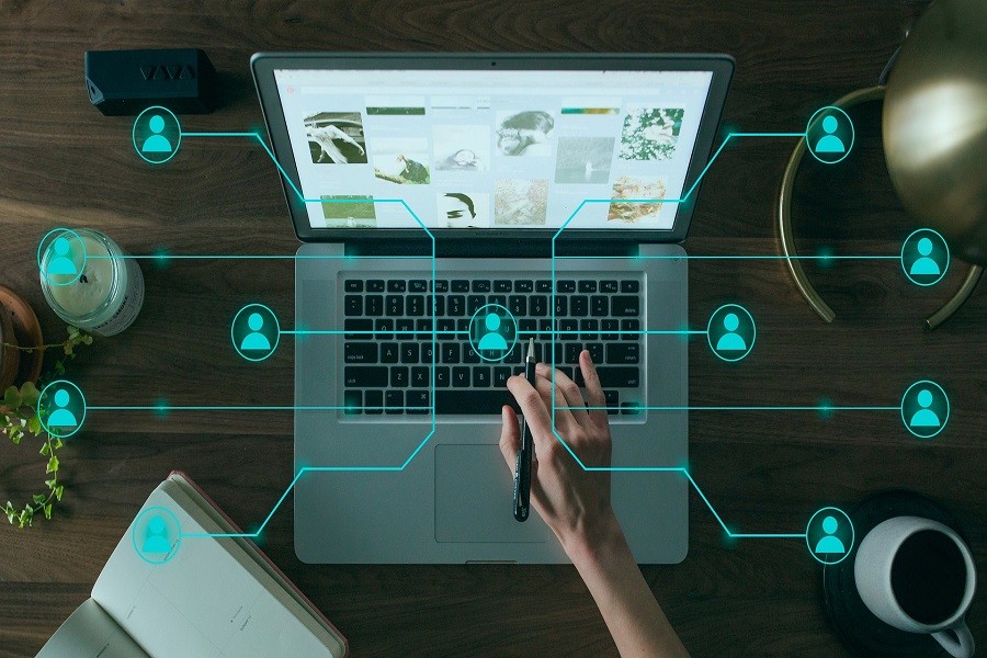 Close up of laptop with user hand overlayed with data network abstract 