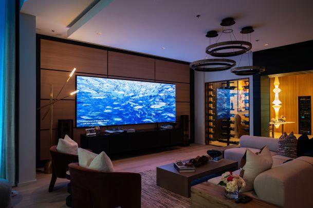 Stylish living space with a large Just Video Walls screen showing an underwater ocean scene with fish.