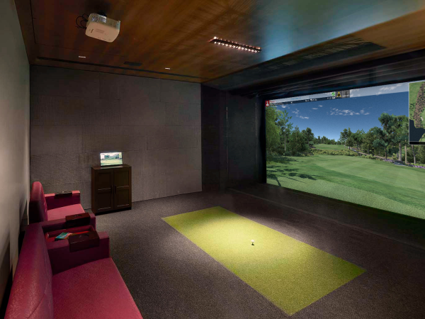 A golf simulator setup featuring a powerful projector and detailed golf course visuals.